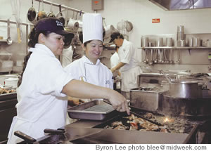 Chef Linda Yamada gives LCC student Narcesa Fukuda (left) a few pointers on her grilling technique