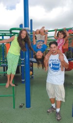New Kalaheo High football coach Chris Mellor enjoys time with daughters (from left) Lexxi, Christyn and Alanna at Maunawili playground. Photo by Nathalie Walker, staff photographer.
