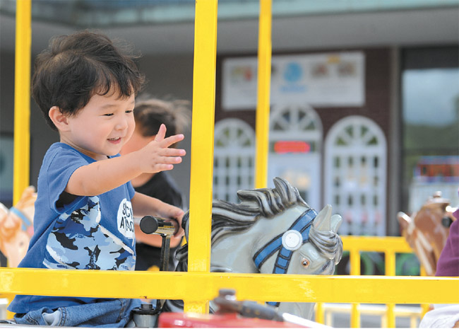 Kody Shishido has a great time on the Carousel Ride at Mililani Shopping Center. The late-summer carnival welcomed families from all over with rides, games and other age-appropriate fun. Photo by Lawrence Tabudlo, ltabudlo@midweek.com.