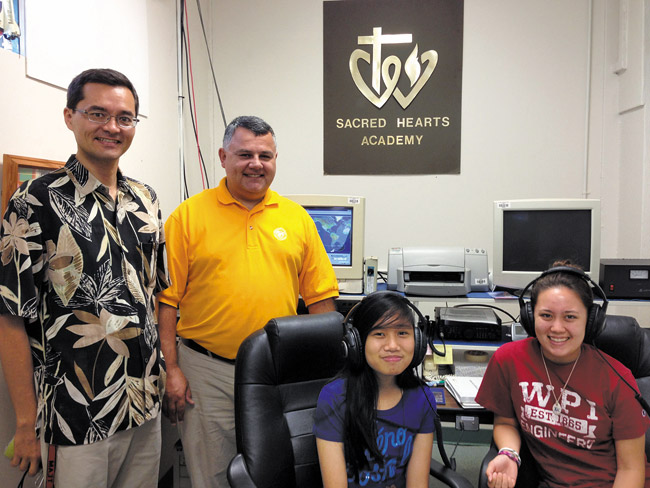 Sacred Hearts' pre-engineering teacher Peter Pak (from left), physics teacher Joe Lyons, students Kristen Tumacder and Dominique Dold at home in the school's NASA Amateur Radio Ground Station. Photo from Hayley Matson-Mathes. 