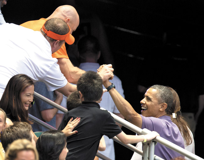 President Barack Obama greets people in the stands Dec. 22 as he takes a break from watching the Oregon State University versus University of Akron college basketball game at the Diamond Head Classic at Stan Sheriff Center. AP photo/Carolyn Kaster