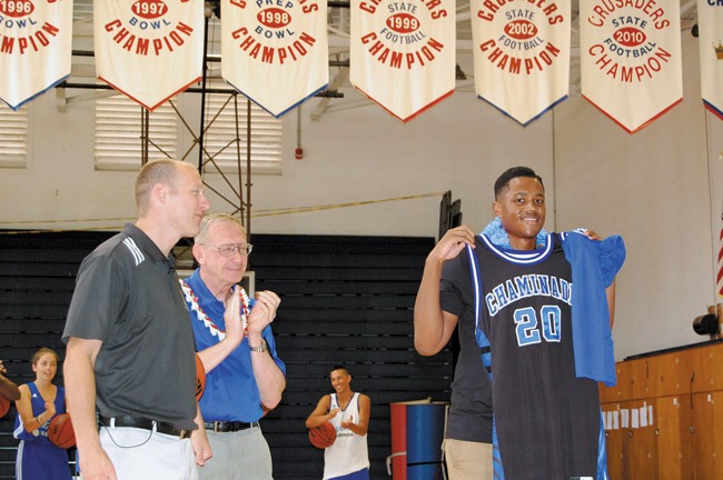 Xhosa Fray-Chinn receives a team jersey from Chaminade University basketball coach Eric Boviard (left) and president Brother Bernie Ploeger. Photo from Bob Hogue