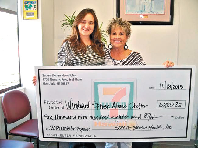 Suzie Henyan (left), donations coordinator for 7-Eleven Hawaii, presents Windward Spouse Abuse Shelter director Avis Kalama with a check for $6,980.85 from its annual canister drive. Photo from Donna Ho'omanawanui. 