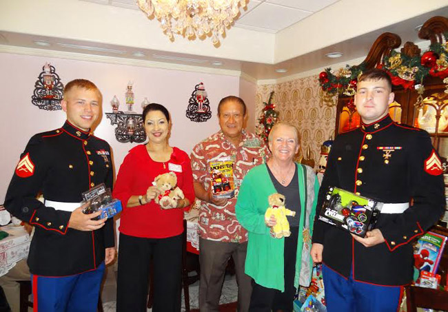 Kailua Chamber of Commerce's annual Holiday Mixer Dec. 12 at A Cup of Tea also collected items for the U.S. Marines' Toys for Tots. Showing off some donations at the event are (from left) Corp. David Win-ship, Darlene Pahed, Puna Nam, Linda Goldstein and Corp. John Cool. Photo from Jay Pahed. 