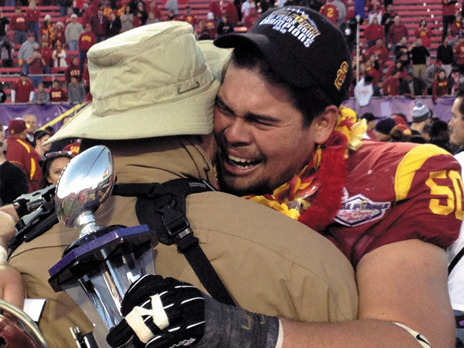 Tearful Trojan Abe Markowitz hugs dad Barry following the USC vs. Fresno State Las Vegas Bowl after winning the prestigious Outperformer Award | Mike Enzenbacher photo