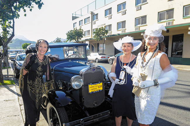 Karen Kralovansky (left) and Anela Lani Grace Belegaud (right), who won the fancy hat contest, and Pat Blaine, who won a bottle of 'Downton Abbey' wine, pose in period costumes with a 1930 Ford Model A Jan. 4 on Uluniu Street during A Cup of Tea Victorian Tea Room's 'Downton Abbey'-themed party to welcome the new season of the PBS drama in style. Photo by Lawrence Tabudlo, ltabudlo@midweek.com. 