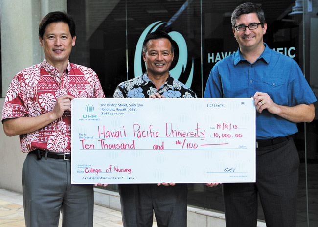 University Health Alliance CEO Howard Lee (left) gives Hawaii Pacific University's development director Kevin Takamori and provost Matthew Liao-Troth a ceremonial check for $10,000 to benefit HPU's College of Nursing and Health Sciences, located on the Kaneohe campus. Photo from Chris Aguinaldo. 