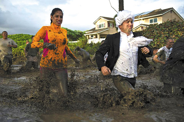 Runners at last year's Swamp Romp try for an air of dignity while sloshing along the 3.5-mile course on Marine Corps Base Hawaii, where military and civilians form teams and absorb plenty of mud. Photo courtesy Marine Corps Community Service.