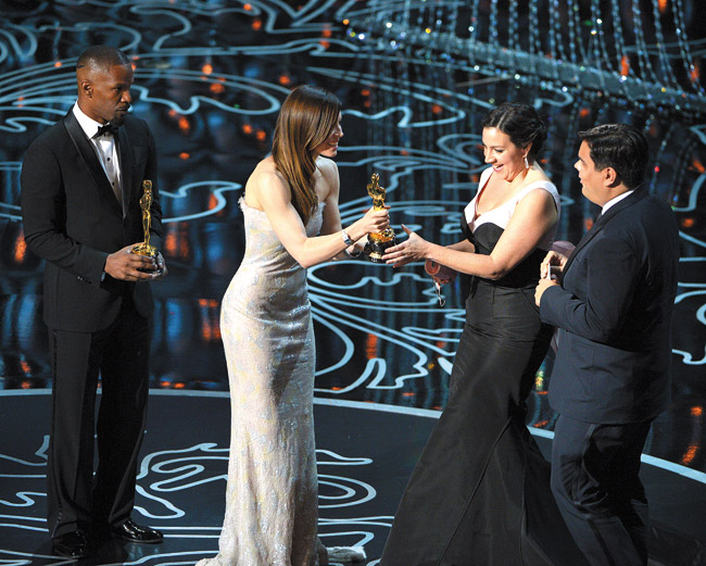 Jamie Foxx (from left) and Jessica Biel present Kristen Anderson-Lopez and Robert Lopez with the award for an original song in a feature film for 'Let It Go' from 'Frozen' during the Oscars March 2 | John Shearer/Invision/AP