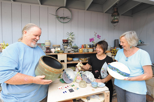 Getting ready for their second annual Pots 'n Plants sale in Kaneohe Saturday are some of the artisans with their creations. They are (from left) ceramics teacher and artist Steve Martin, plant expert Elsie Horikawa, ceramics artist Lori Nakatsuka, potter and dish garden artist Karen Kim, glass artist Ruth Canham and ceramics artist Don Fowler. Kim's three-car carport and lawn will be overflowing with pots and plants offered by close to a dozen local talents. Photo by Lawrence Tabudlo, ltabudlo@midweek.com. 