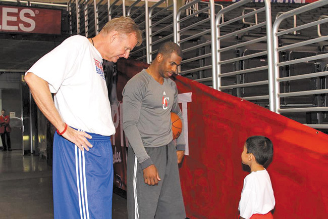 Dave Severns, director of player development, L.A. Clippers, and Clippers guard Chris Paul talk with a young basketball camper. Photo courtesy Byron Mello