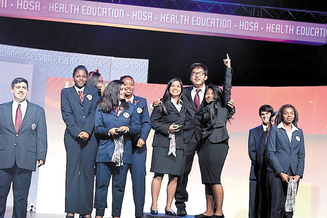 Rejoicing national champions from Mililani High School's delegation to the recent HOSA-Future Health Professionals' conference in Orlando are (from left, group with No. 1 salute) Fejiereich Luz Lopez, Mason Matsuo and Chasidee delaCuesta-Batara. Photo from Candace Chun. 