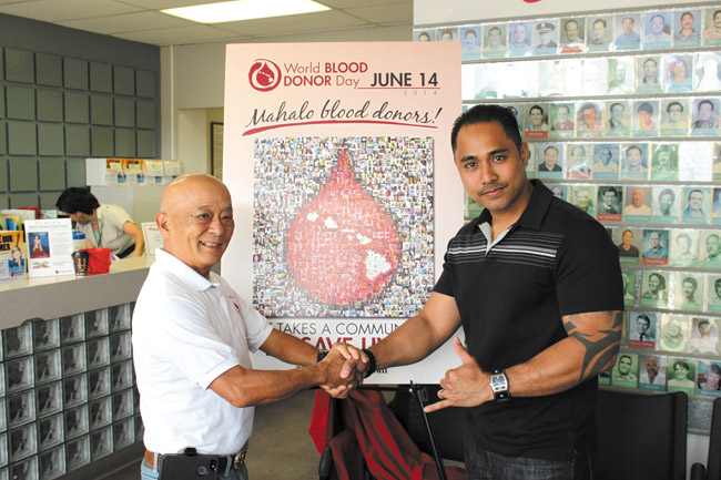 Veteran donor and Waipahu resident Francis Nagata (left) with new super donor (56 pints or more) Dustin Guillermo in front of the World Blood Donor mosaic at Blood Bank of Hawaii's Dillingham Boulevard headquarters. Photo from Vanessa-Helen Sim.