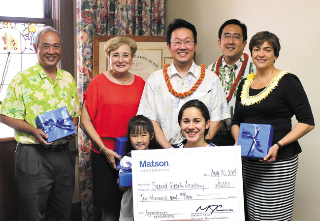 Matson Foundation added $10,000 to Sacred Hearts Academy's gym fund. At the check ceremony: (front, from left) students Callie Yonemoto and Aina Katsikas, (back) SHA board chairman Terence Enriquez, head of school Betty White, SHA human resources officer Chad Yonemoto, Matson vice president Ku'ukahu Park and SHA board member Shanlyn Park. Photo from Hayley Matson-Mathes. 
