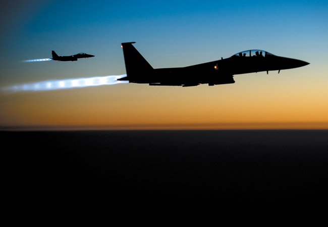 A pair of U.S. F-15E Strike Eagle flies over northern Iraq Sept. 23 after conducting airstrikes in Syria. U.S.-led coalition warplanes bombed oil installations and other facilities in territory controlled by Islamic State militants in eastern Syria Sept. 26, taking aim for a second consecutive day at a key source of financing that has swelled the extremist group's coffers, activists said AP PHOTO/U.S. AIR FORCE, MATTHEW BRUCH 