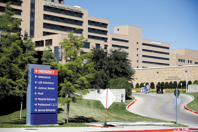 Medical staff walk up the drive to the emergency room area at Texas Health Presbyterian Hospital in Dallas AP PHOTO/TONY GUTIERREZ
