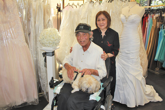 Married life is a bliss for Roy and Irene Nagahara, pictured here with their dog Bento at their Princess Brides shop on Kapiolani Boulevard PHOTO COURTESY S. SAGISI