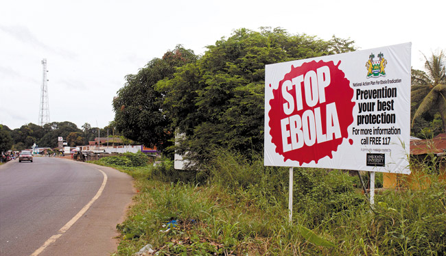 In this photo taken Oct. 21, a billboard reading 'Stop Ebola' has been placed on Masiaka Highway, forming part of a trans-West African highway, which links all West African states, on the outskirts of the capital city of Conakry, Guinea AP PHOTO/YOUSSOUF BAH