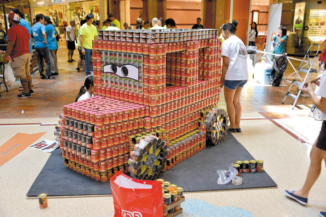 Each year, AIA Honolulu Chapter invites teams of local architects, builders and engineers to compete in its Canstruction competition, erecting buildings made entirely of canned food. Last year, ADM Retail Planning and Architecture competed with its entry, 'Join the Race to Drive Out Hunger.' This year's competition takes place Saturday at Pearlridge Center, Uptown Center Court. Photo by Doug Blagriff.