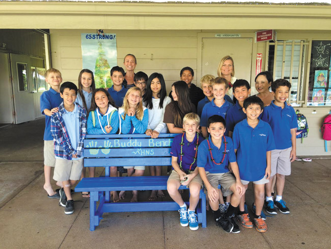 Christian Bucks (seated, left) with Caden Lombard (seated, right) and his clasmates with their Buddy Bench PHOTO COURTESY HOLY NATIVITY SCHOOL 