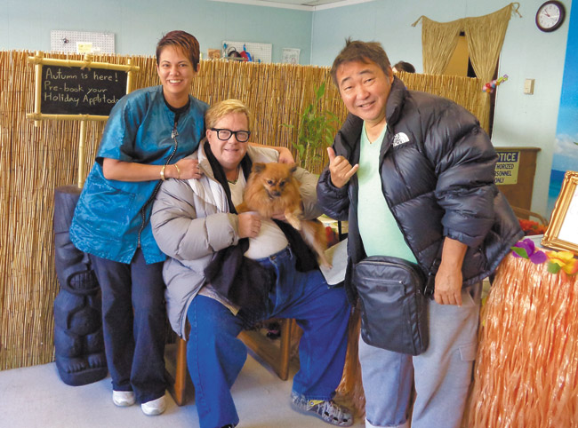 Sara Reynolds, owner of Tiki Tails Dog Beauty Salon, with Eric Chandler (center), Takeo Kobayashi and their dog, Chibi, in Buckley, Wash. PHOTO COURTESY ALOHA TIKI TAILS 