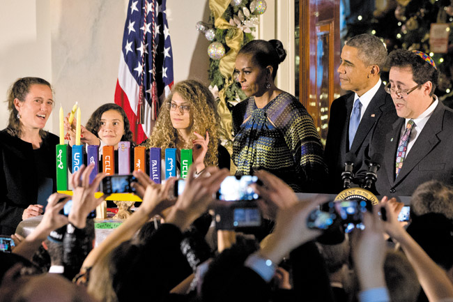 Rebecca Bardach, with the Max Rayne Hand in Hand Bilingual School in Jerusalem (far left), watches as Inbar Vardi and Mouran Ibrahim, who are both students at the school, light candles for the second night of Hanukkah Dec. 17 with first lady Michelle Obama, President Barack Obama and Rabbi Bradley Shavit Artson, during the first of two Hanukkah receptions in the Grand Foyer of the White House. The two Israeli ninth-grade students, Vardi, who is Jewish, and Ibrahim, who is Muslim, lit the candles as the blessings were recited AP PHOTO/JACQUELYN MARTIN 