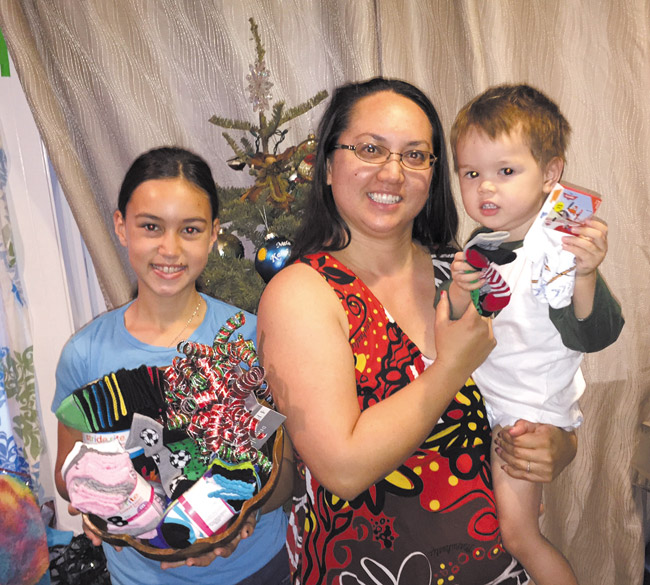 (from left) Amaris, Mai and Tiberius Hall get ready to wrap presents for their ‘Socks for Tots' Christmas project PHOTO FROM JASON HALL