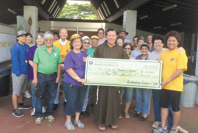 Holding the $10,000 Weinberg Friends check for Our Lady of Mount Carmel Church are (from left) Shirley Kaluhiwa of Kahaluu Lions Club, Father Paulo Kosaka and Kahaluu Lion Liane Garrett. The donation was presented following a successful beautification workday Nov. 22 at the Waikane church by Kahaluu and other Windward Lions club volunteers as well as friends of the church, which will use the grant for its food pantry (no one is turned away). Photo from Bob Putes. 