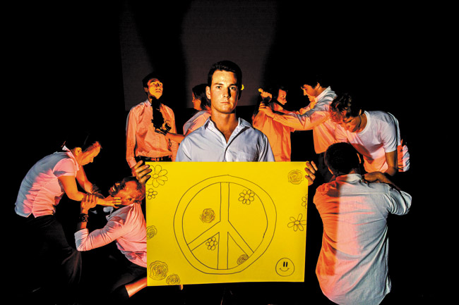 Windward Community College theatre student Jackson Shimanoff (center) portrays ‘Poet,' who protests the violence around him, as seen in (from left) Catherina Chon, Eric Jabarri Combs, Noa Helela, Sorsha Scott-Holmes, Malia Galindo, Scott Peiterson, Austin Sunderman and Toby Carvalho. They are rehearsing the ‘Give Peace a Chance' scene from ‘Agamemnon,' which opens Friday at Paliku Theatre. Photo by Daniel Mayberry. 