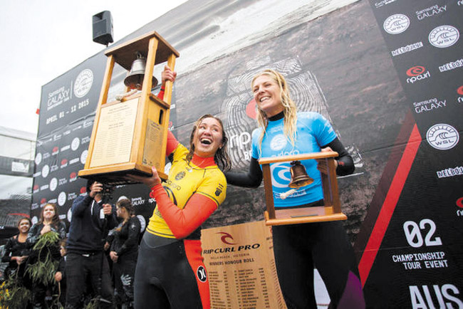 Carissa Moore (left) and Stephanie Gilmore hoist their firstand second-place trophies at Bells Beach, Australia. World Surfing League photo. 