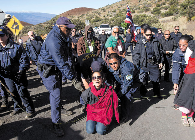 Department of Land and Natural Resources officers arrest a protester on the road to the Thirty Meter Telescope site April 2 on the summit of Mauna Kea HAWAII TRIBUNE-HERALD, HOLLYN JOHNSON / AP PHOTO  