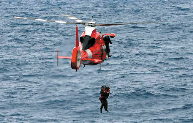 A Coast Guard helicopter plucks a downed pilot from the sea USCG PHOTO