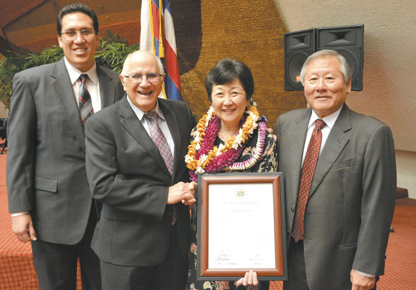 The state House of Representatives honored Windward Community College professor Libby Young April 2 for her outstanding contribution to journalism and her role in devel- oping the WCC campus master plan. Young (holding the House certificate) retires in May after 35 years of teaching and service. With her are (from left) Rep. Jarrett Keohokalole, House Speaker Joe Souki and Rep. Ken Ito. PHOTO BY JANINE TULLY.