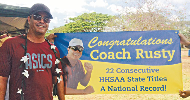 Rusty Komori stands in front of the banner his Punahou players presented to him after his latest state title PHOTO COURTESY RUSTY KOMORI