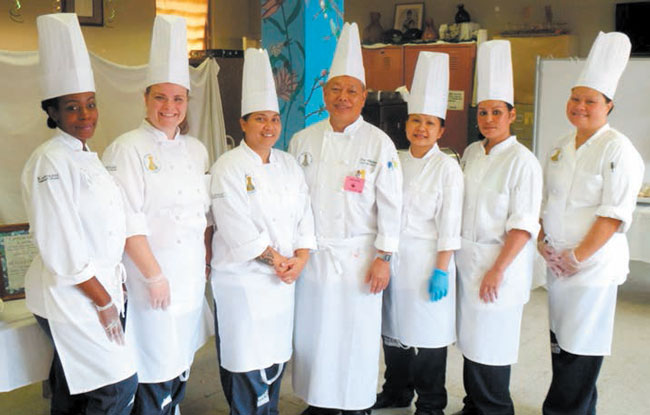 Head chef Lee Shinsato of KCC (center) stands with his newly graduated culinary class students at Women’s Community Correctional Center in Kailua. PHOTO COURTESY STATE DEPARTMENT OF PUBLIC SAFETY.